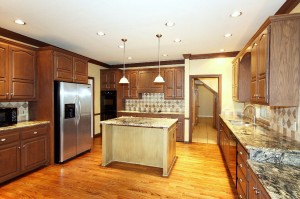 Remodeled kitchen with granite countertops, tiled backsplash and kitchen island with bar seating