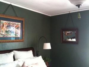 Beautiful picture and mirror hanging from wires attached to crown molding