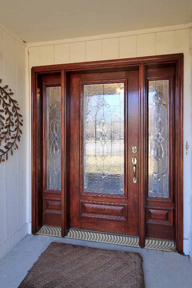 large covered entry exterior with custom wood door