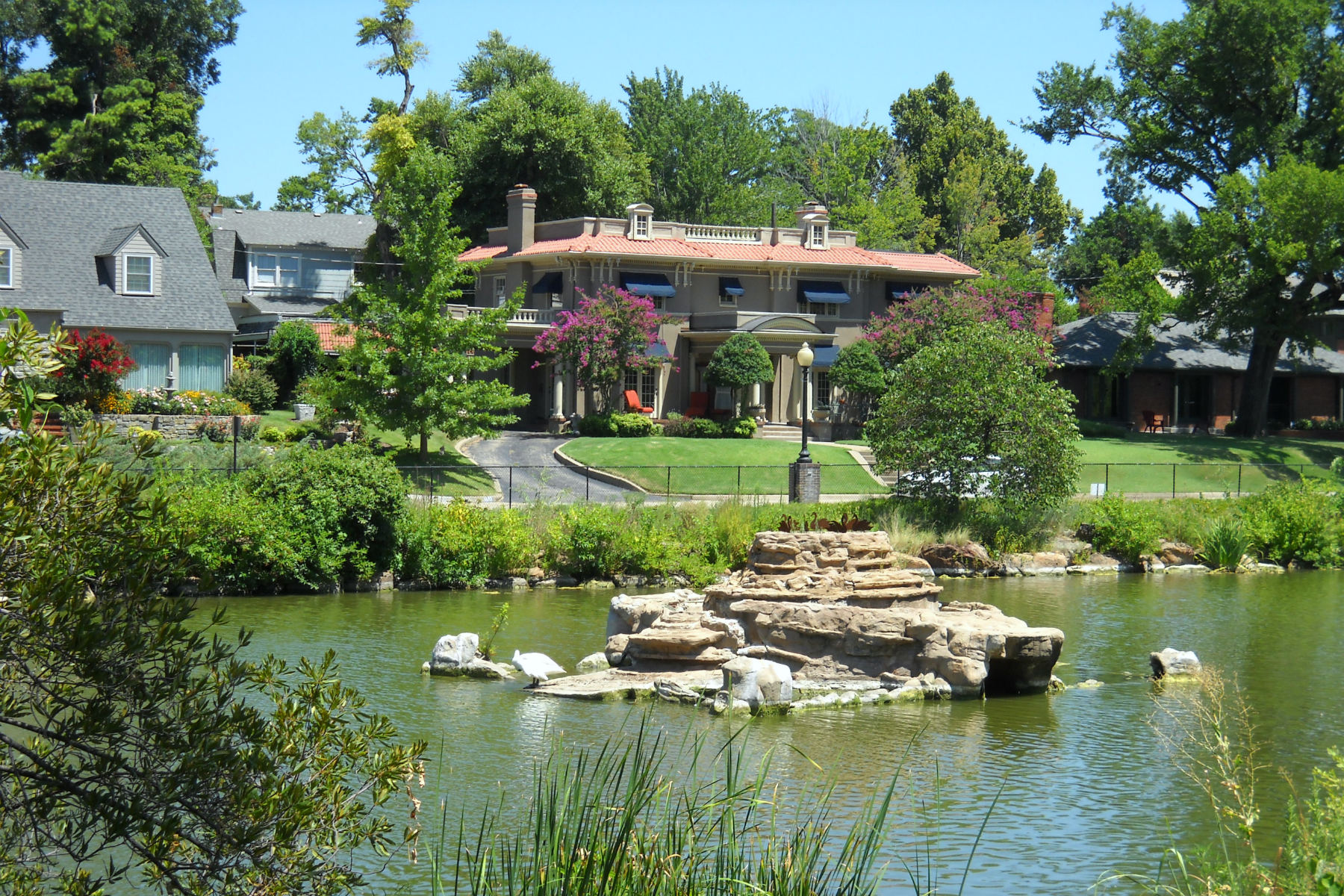 Photo of large stucco home and lake in the Swan Lake neighborhood of Tulsa, OK